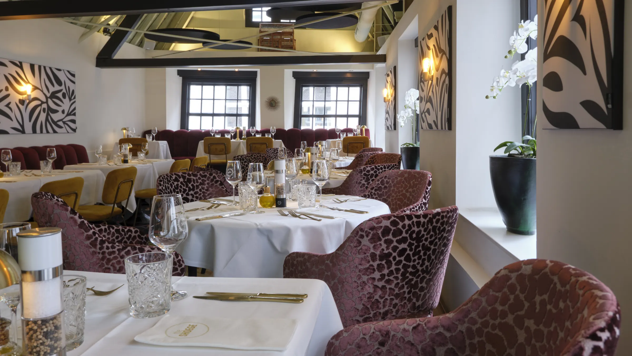 The LOFT bij het raam, met gedekte tafels en luipaardstoelen