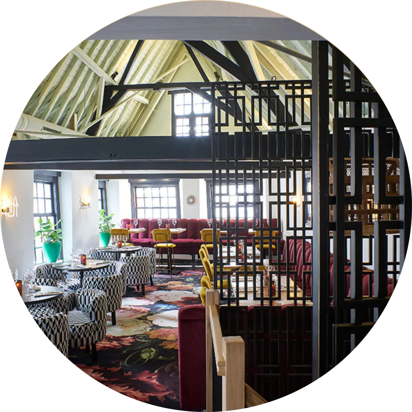 Een grote zaal onder houten dakspanten met zwarte stalen kozijnen