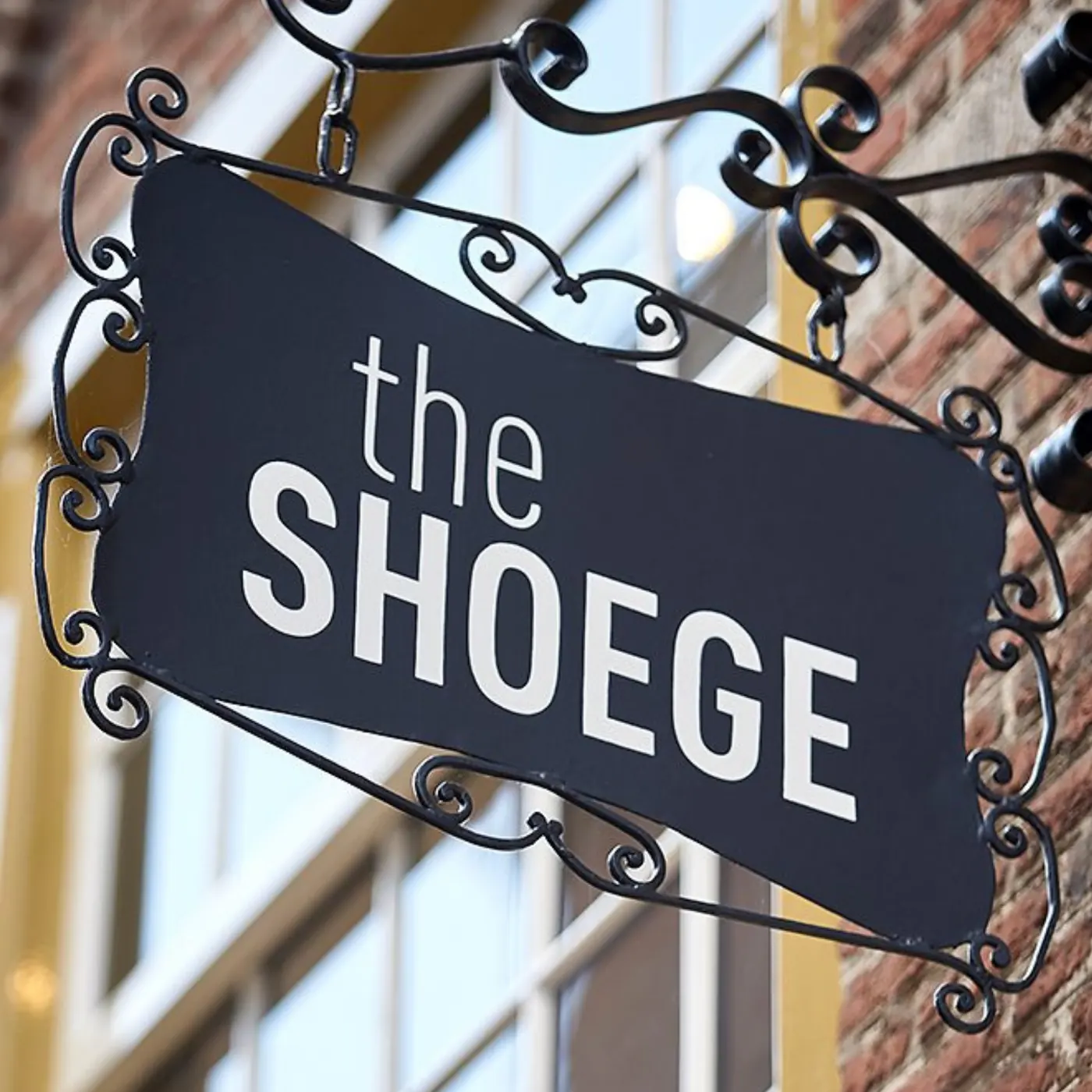 Het uithangbord van The SHOEGE aan de gevel